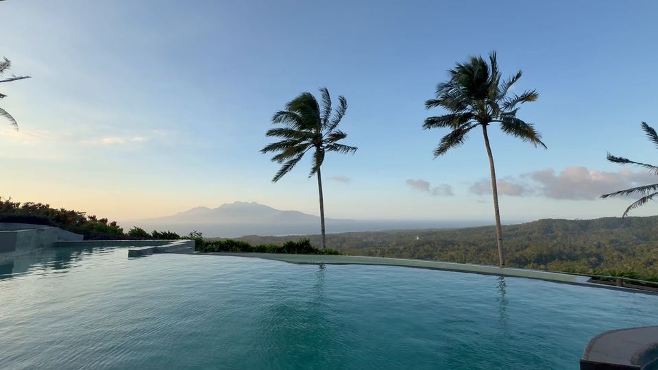 Kithul Cove: an infinity pool edged with palms, looking over green hills towards the sea.
