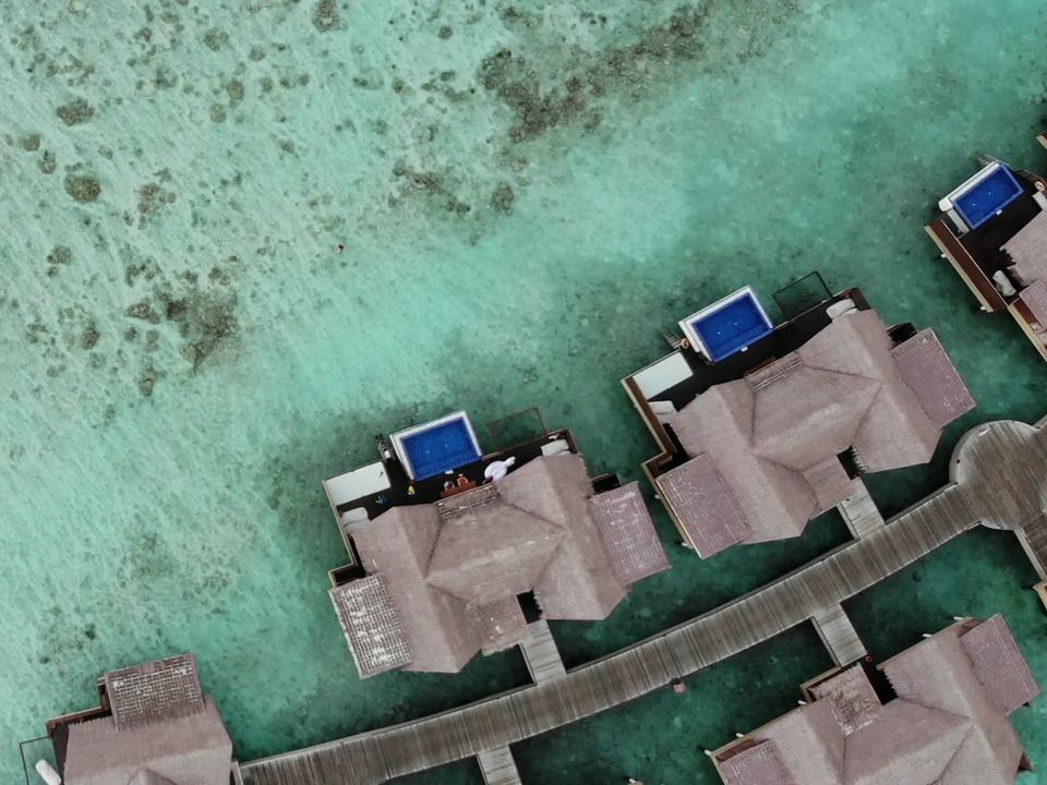 Muhudu: water villas with private pools on a boardwalk over the reef, seen from above.